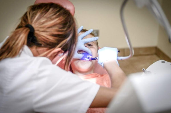dentiste effectuant un examen dentaire à un enfant